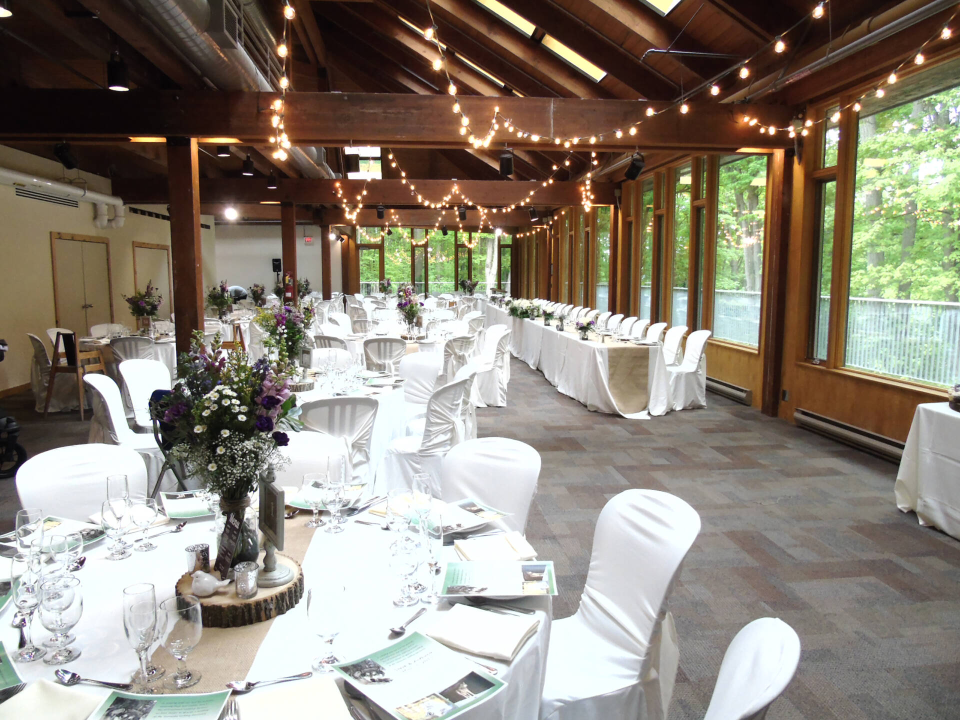 tables and string lights in a wooden building