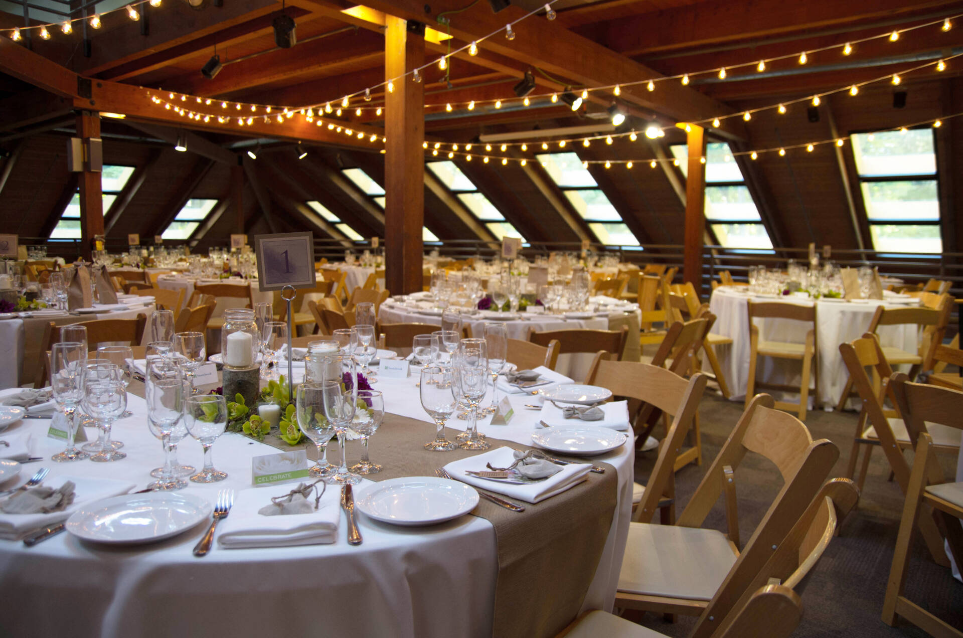 tables and string lights in a wooden building
