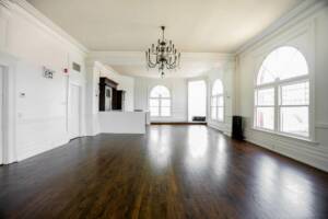 Dark Brown Hardwood Floor with Bright Walls and a chandelier