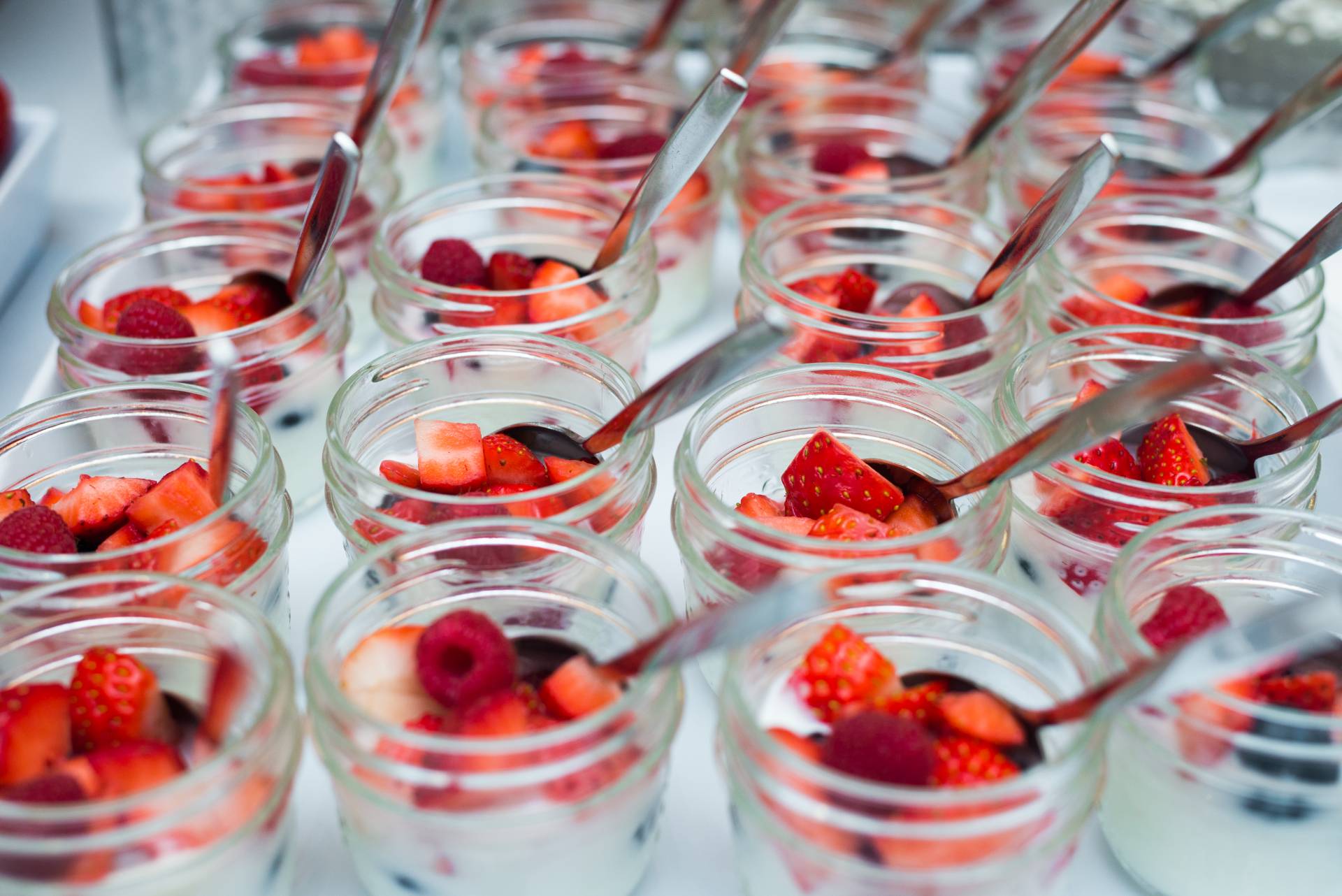Image of Yogurt Cups served in a small glass jar with raspberries, blueberries and strawberries on top.
