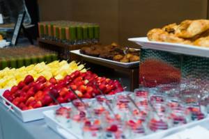 Breakfast Catering Spread, fruit kebabs, yogurt, fruit juice including green juices, baked goods.